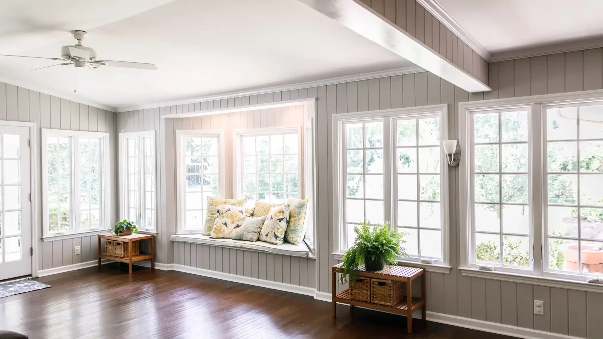 A sitting room with a wall of new windows and hardwood floors A sitting room with a wall of new windows and hardwood floors