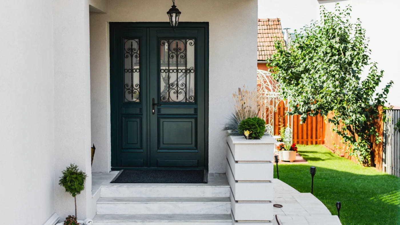 Green entry doors with iron work on glass