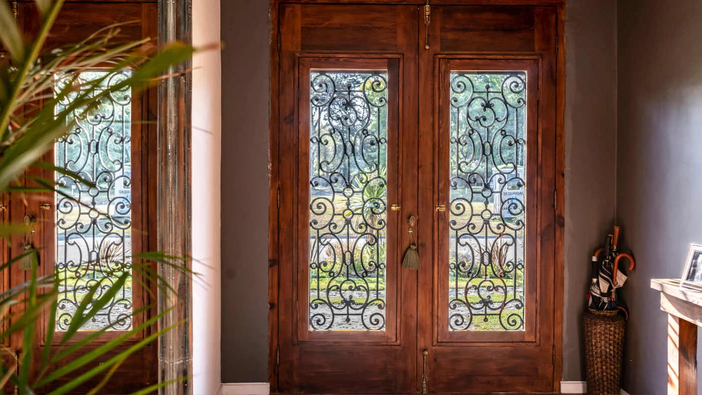 A custom iron door with detailed iron design and a brown frame