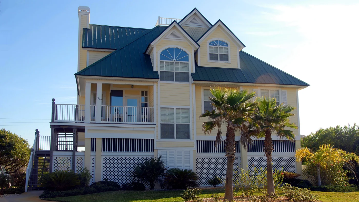 A large yellow home with custom windows and white trim