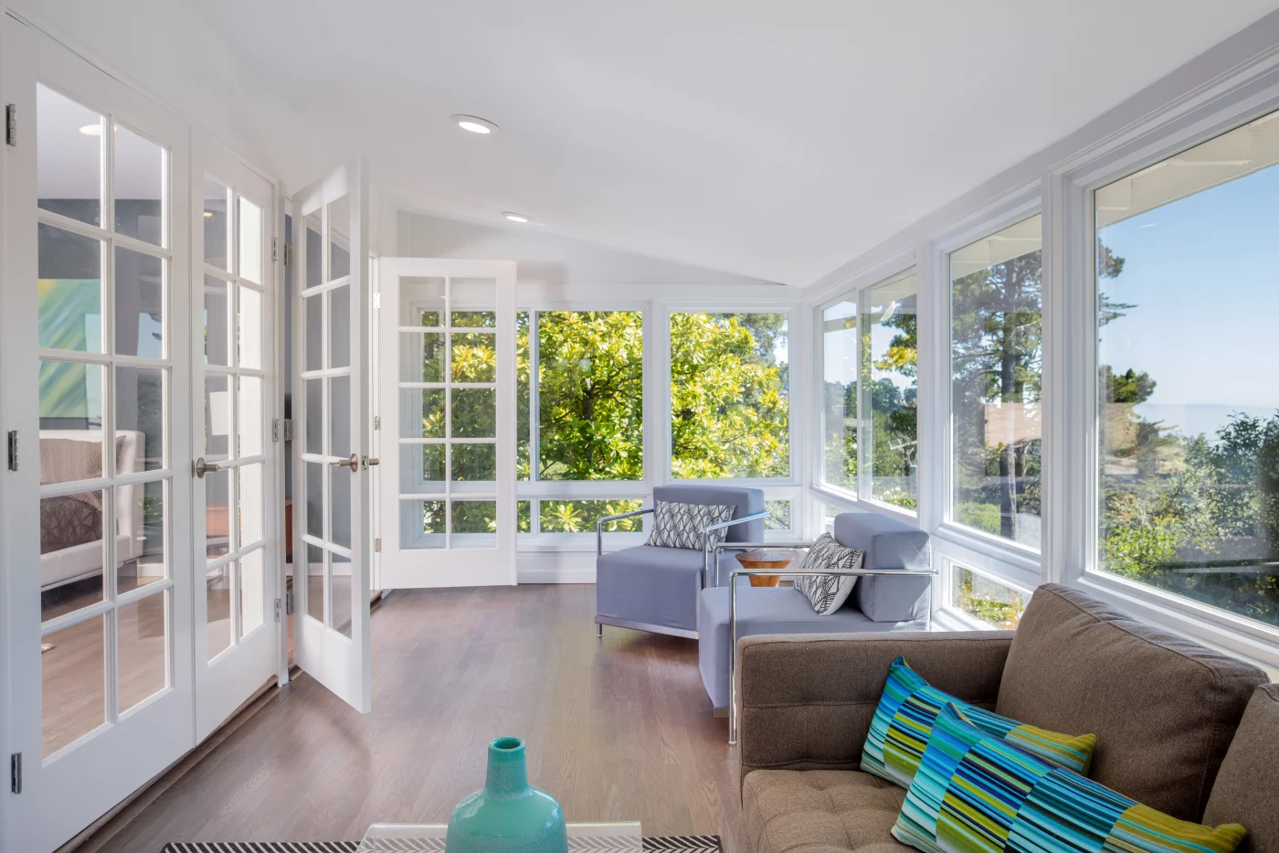 Medium sunroom with white frames and many windows blue and brown furniture