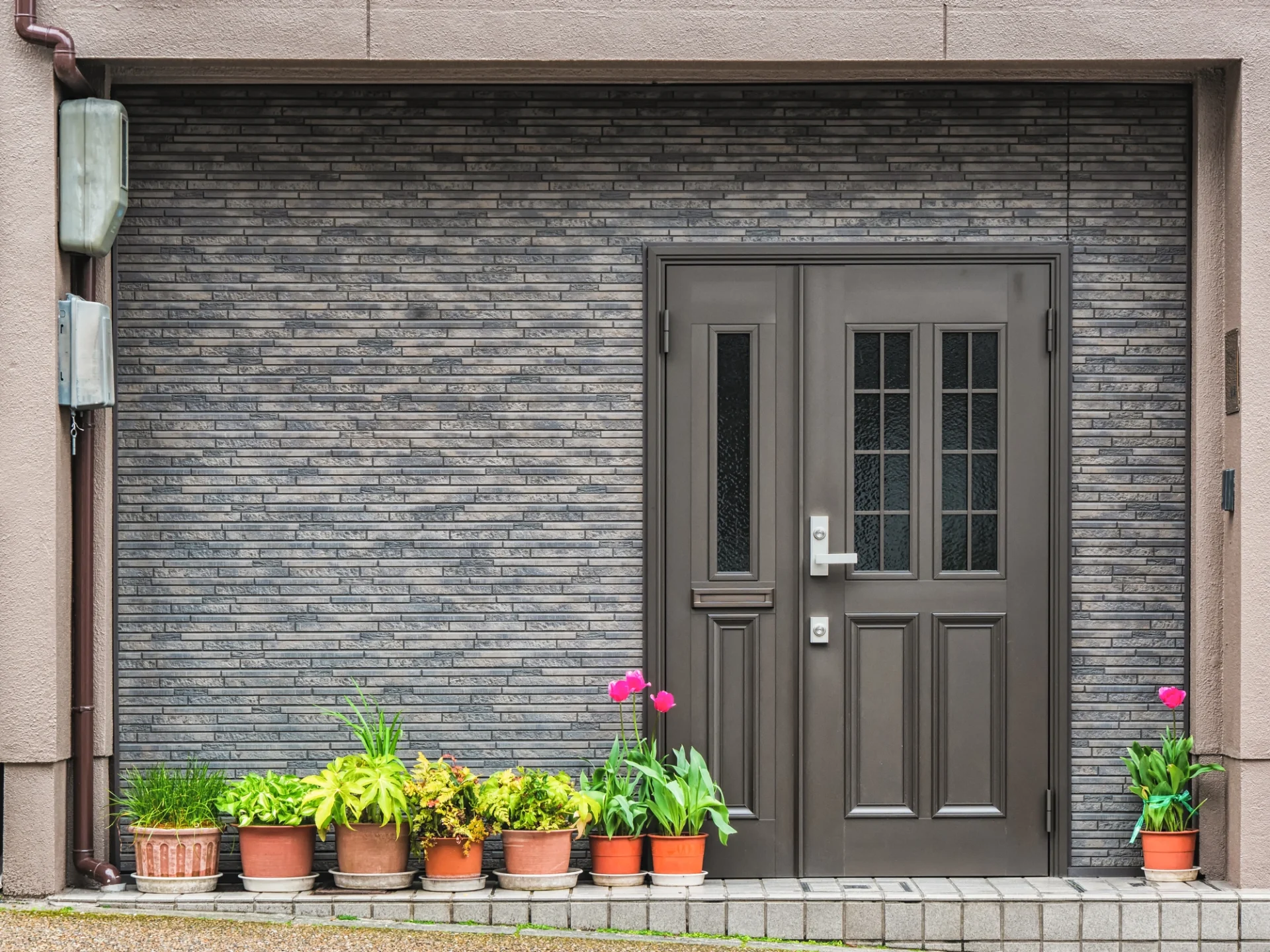 Top Notch Residential Door Replacements Ortega Forest Jacksonville Doors And Windows A sleek, modern front door in dark gray is the focal point of a beautiful gray brick wall at the front of a Northern Florida home