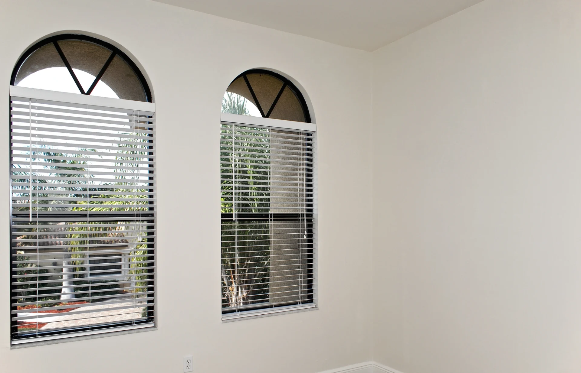 A pair of beautiful arched windows with attractive grilles.