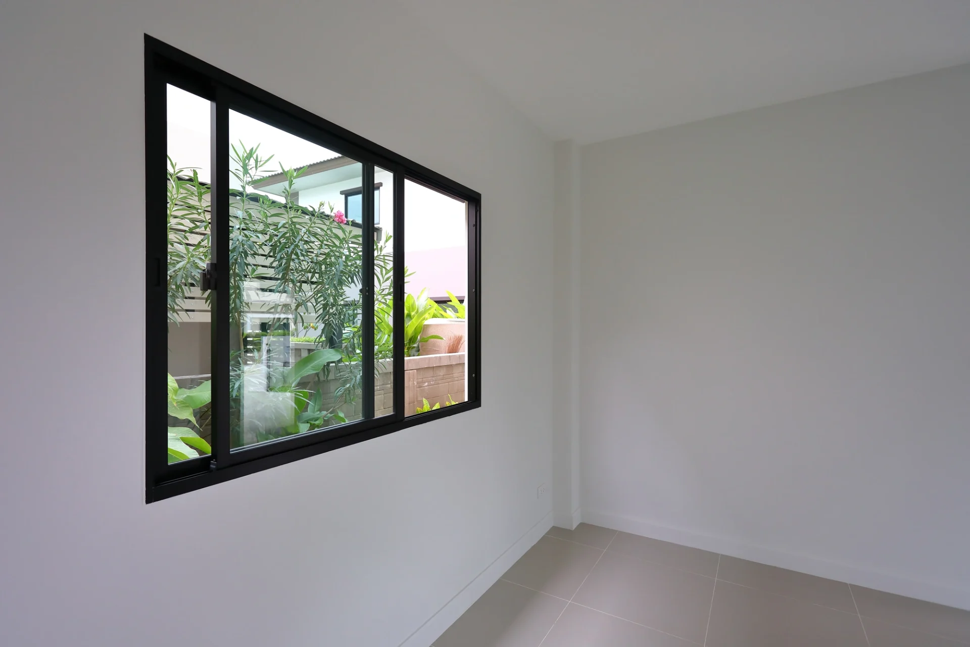 A sleek, black-framed sliding window with a minimalist design
