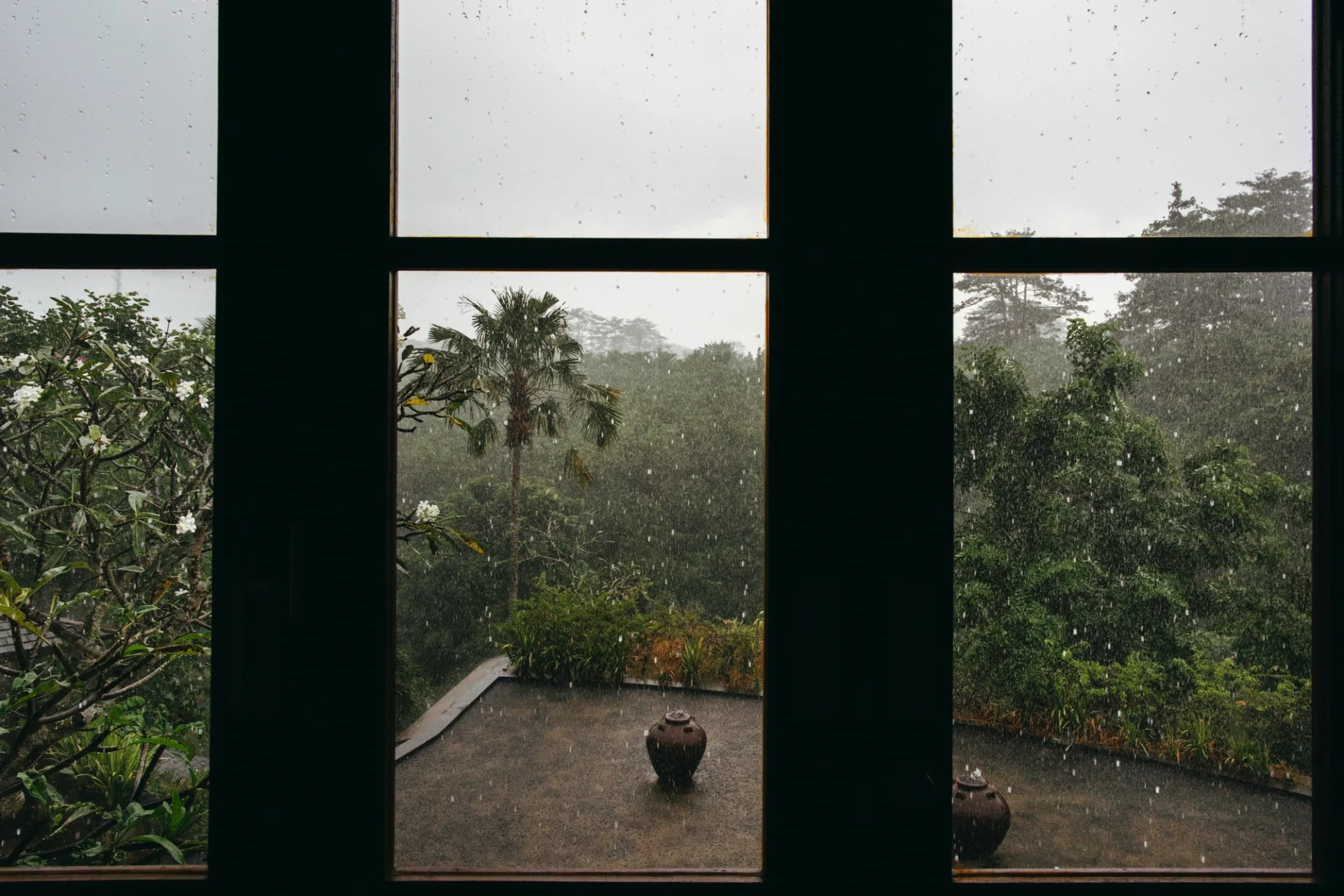 A wide window with a black frame protects a Riverside home from the elements