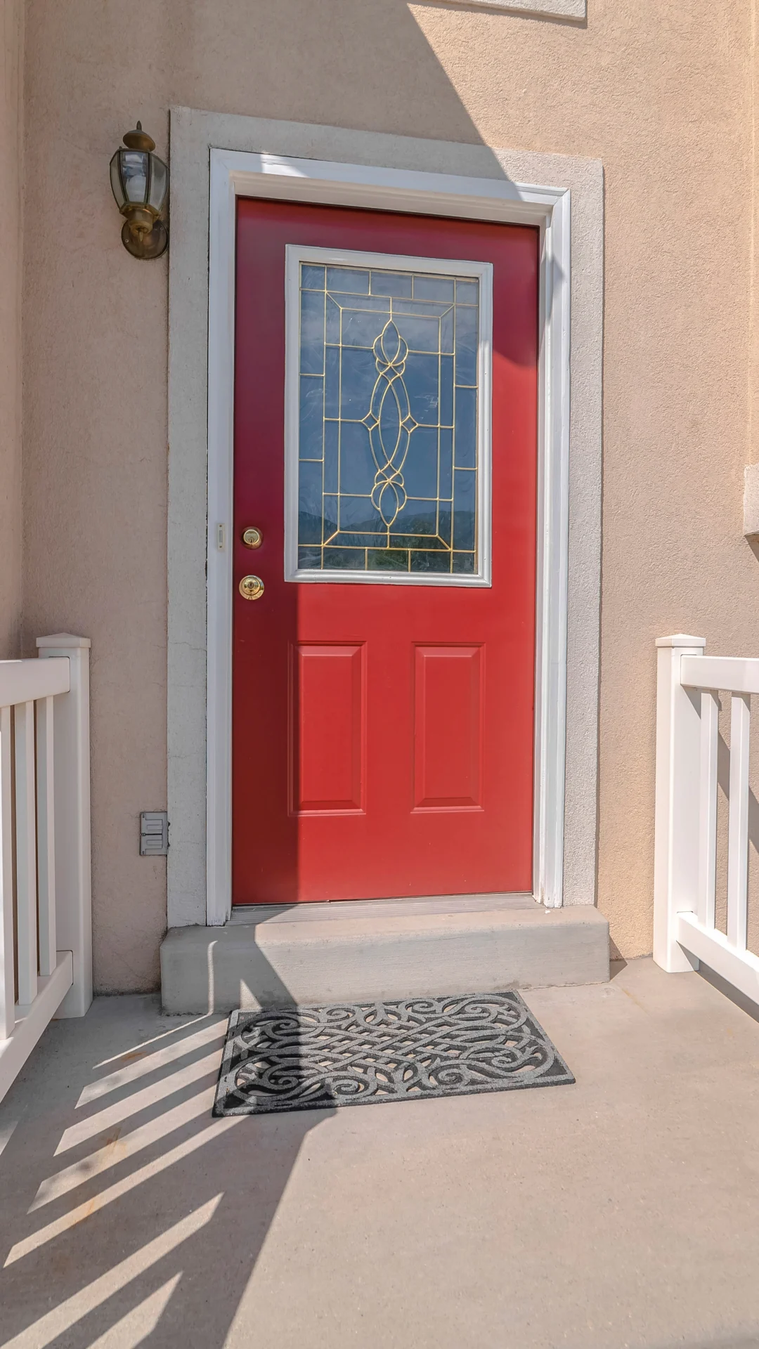A beautiful red entry door features new decorative glass that adds a refined look