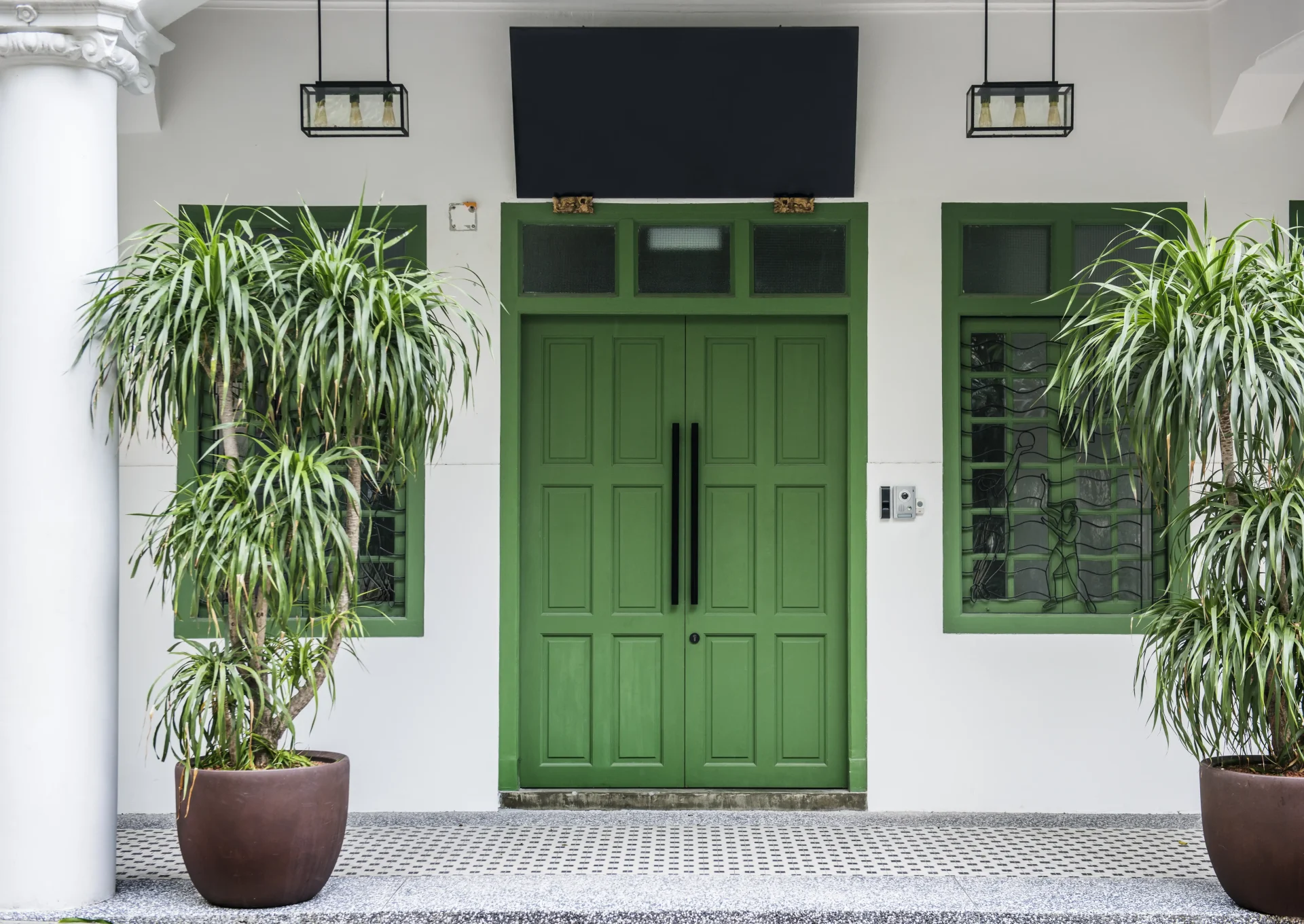 A pair of gorgeous green French doors create an eye-catching focal point for a patio while mirroring the well-tended greenery.