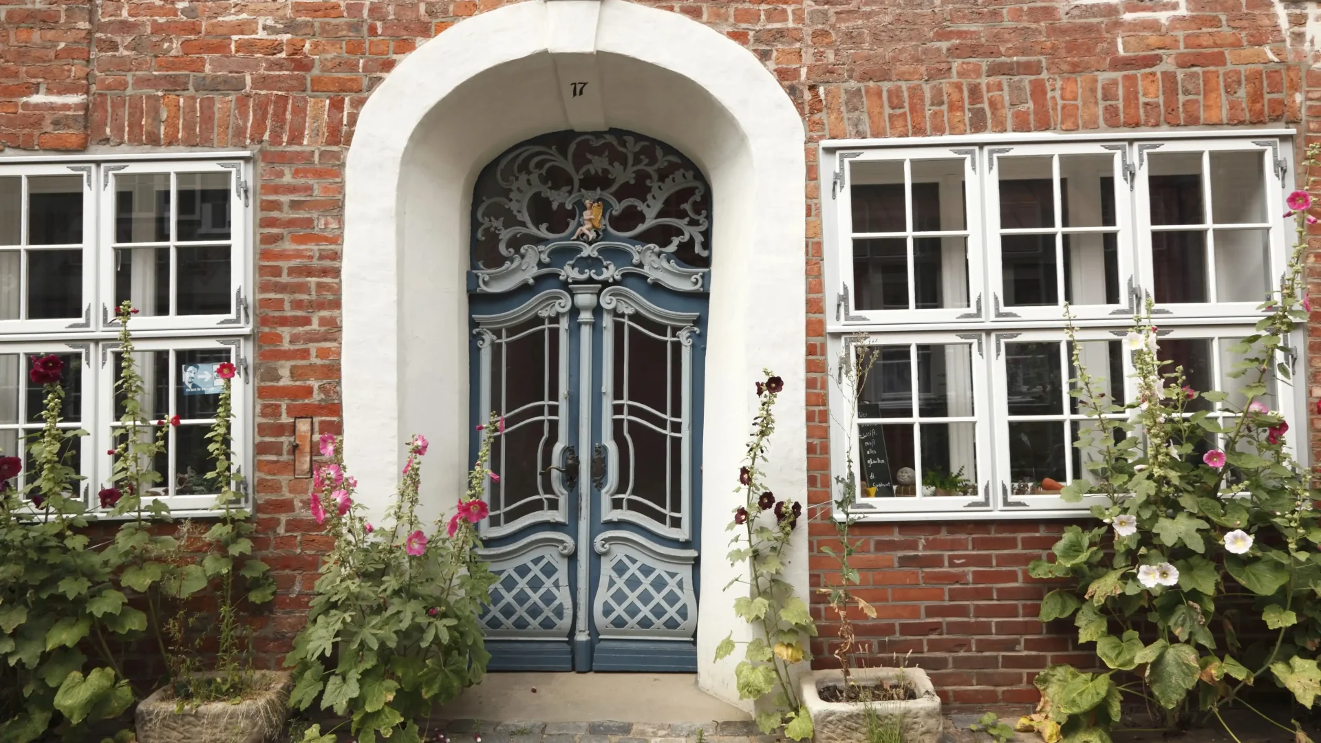 Large rustic home with brick siding and large iron entry door with elaborate design