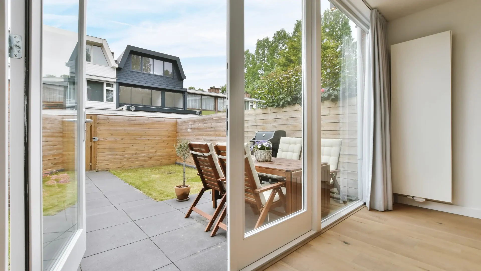 Home with sliding glass patio door outlooking enclosed concrete patio