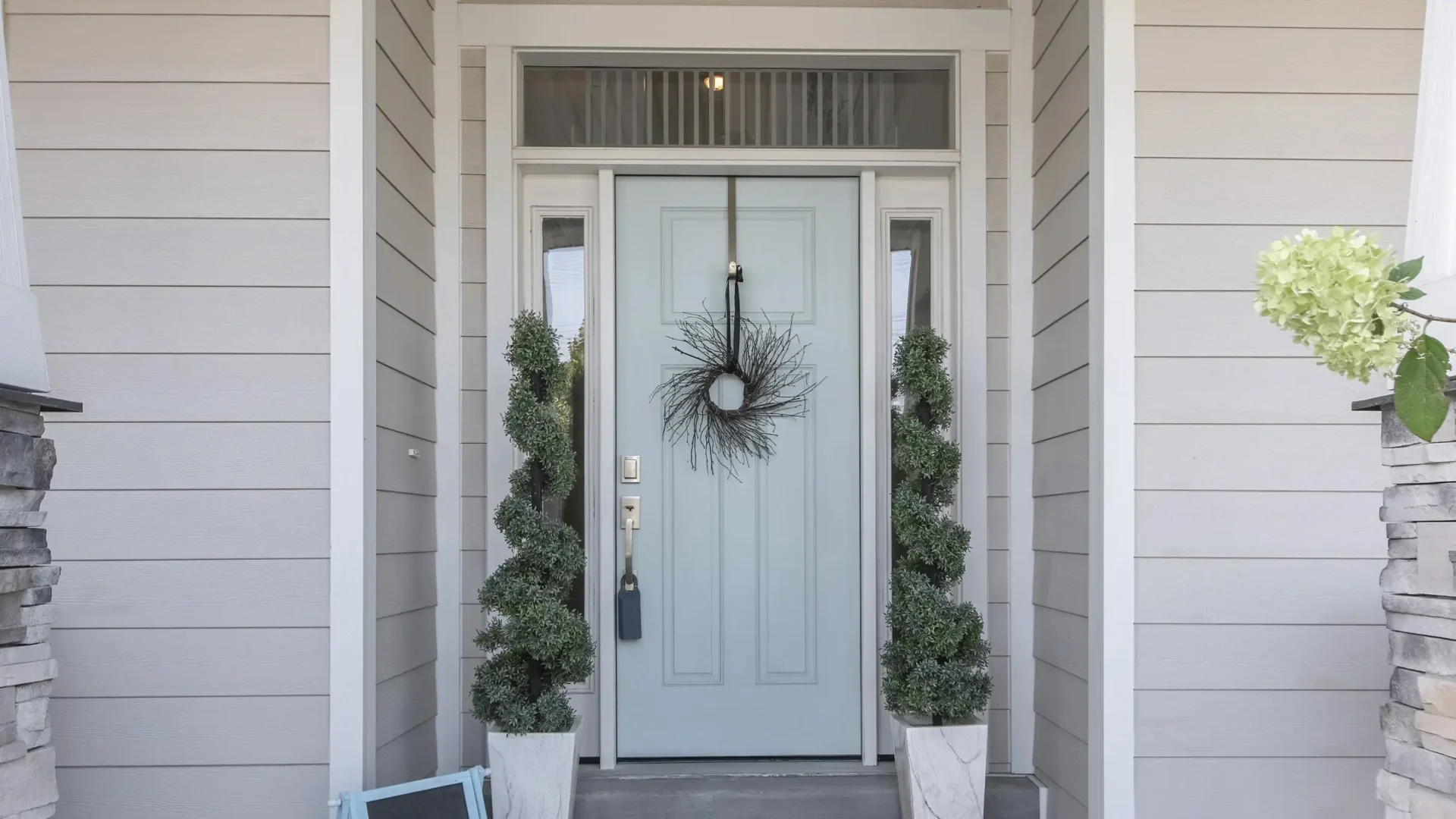 Pale blue-green entry door with wreath on it and glass on both sides
