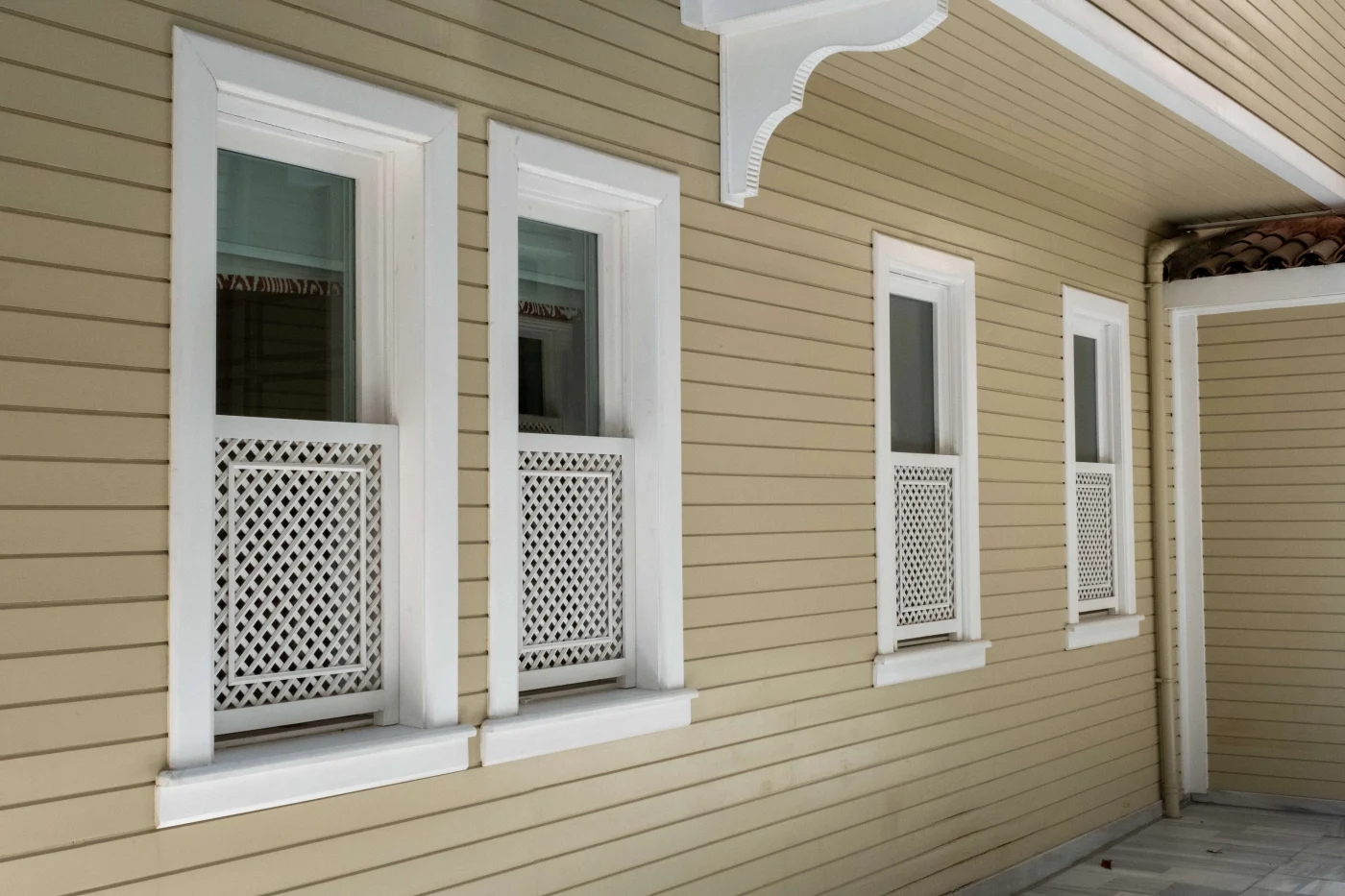 A row of windows against house with dark yellow/gold siding