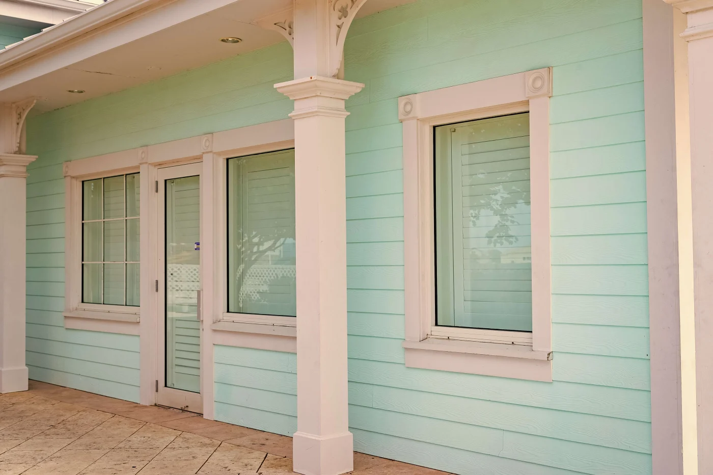 Impact resistant windows installed in home with seafoam green siding