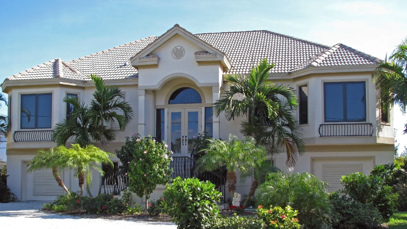 Luxurious stucco house in Julington Creek with spacious windows and tropical shrubbery in front