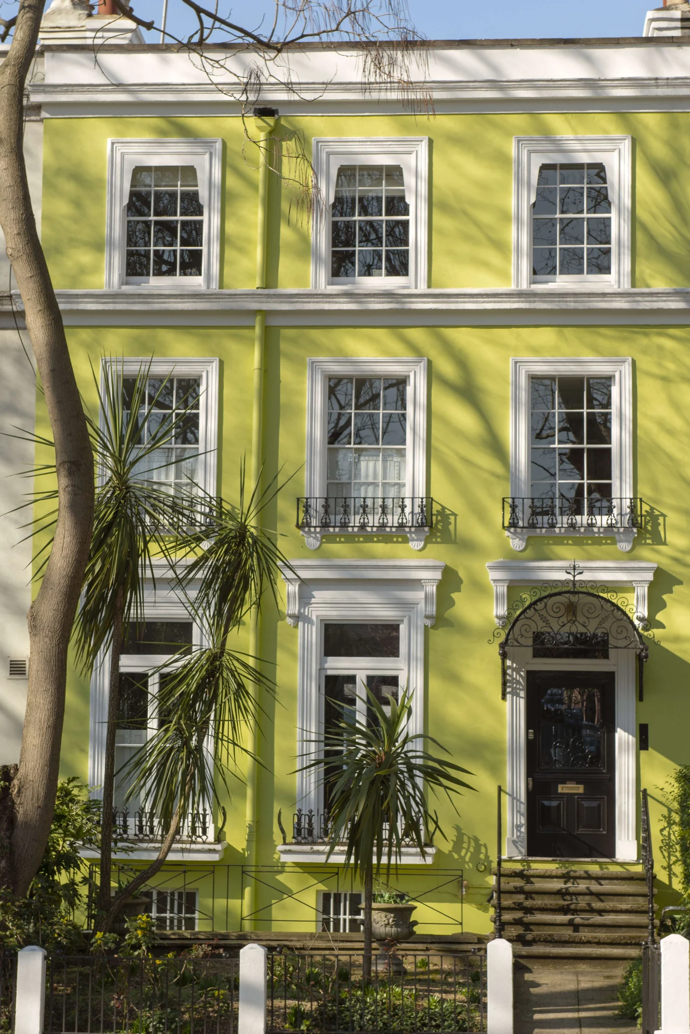 Gorgeous windows with white frames in yellow painted townhome