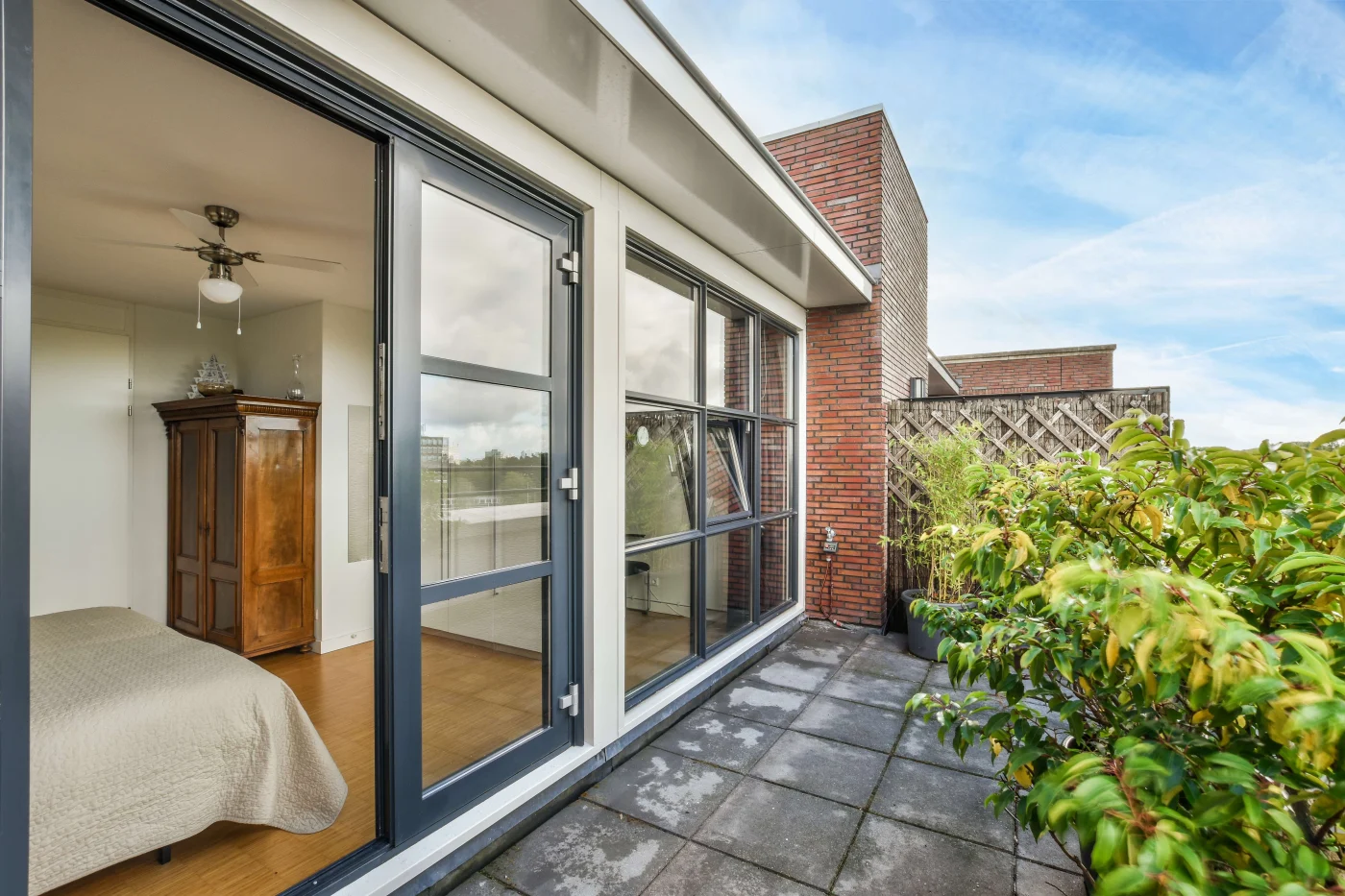 Open sliding glass patio doors looking into a bedroom from a back patio