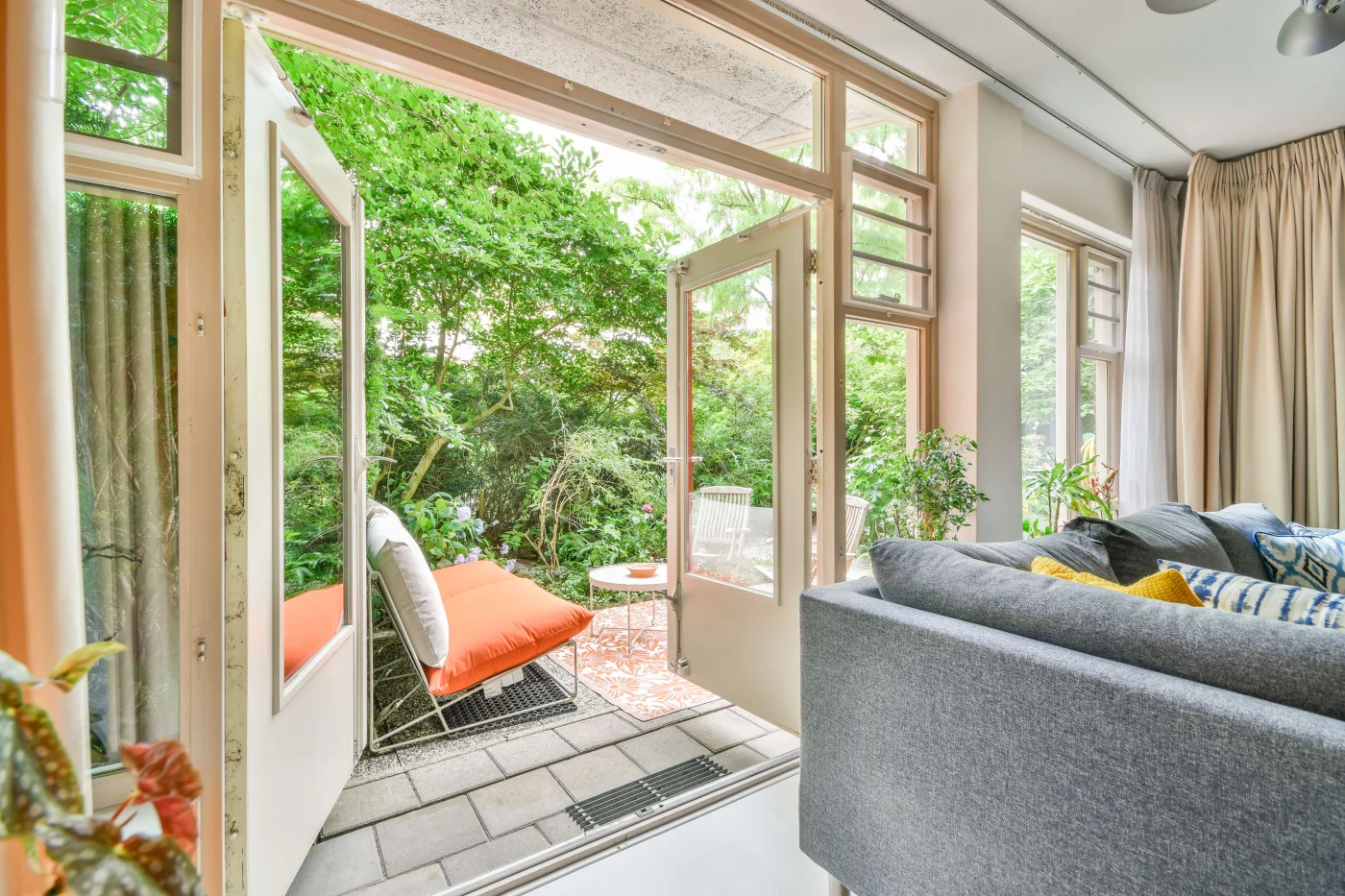 Best Patio Door Replacement In Vilano Beach FL | Jacksonville Doors & Windows French doors opening up to a lush patio with greenery.