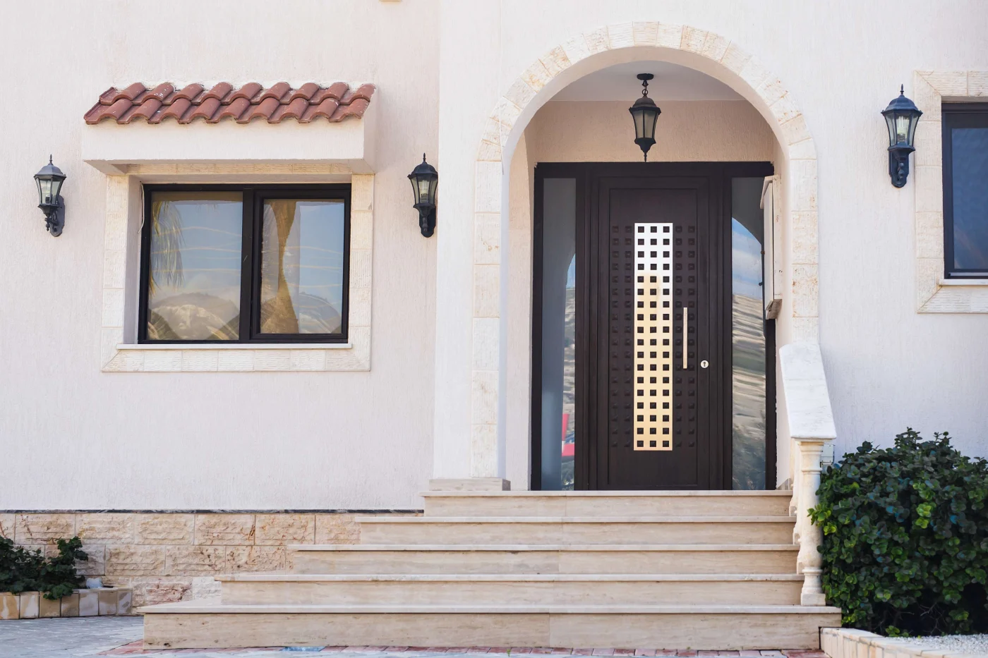 Custom Front Entry Doors in Nocatee, FL | Jacksonville Doors & Windows A Spanish-style house with a new dark iron door with a gold design.