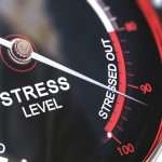 A close-up of a pressure gauge with the needle on the maximum level, titled “STRESSED OUT”