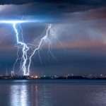 Lightning striking over a coastal Florida city at night.